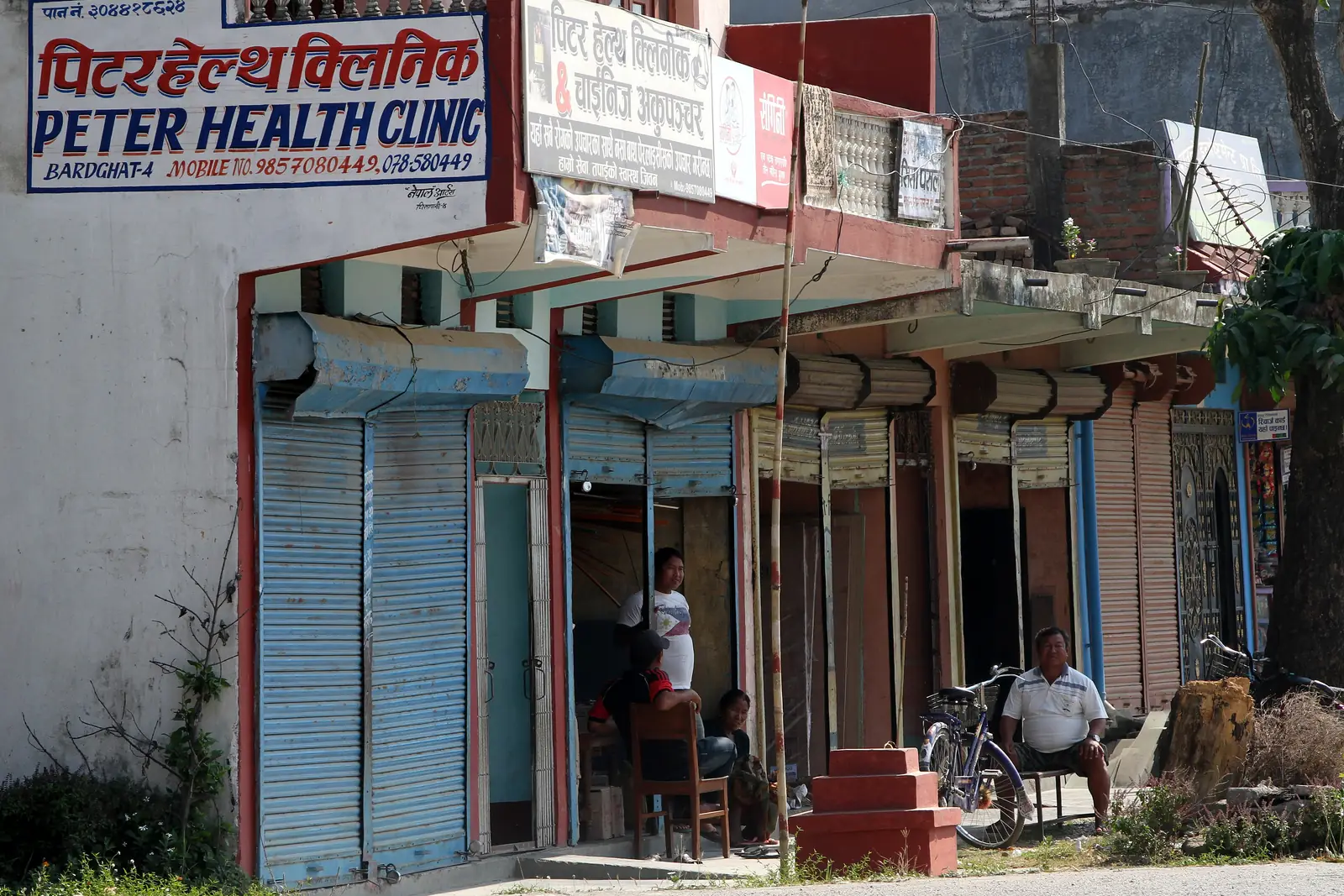 A row of small shops and a health clinic along a street in Bharatpur, Chitwan